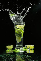 Glass of fresh mojito with splashes on dark background