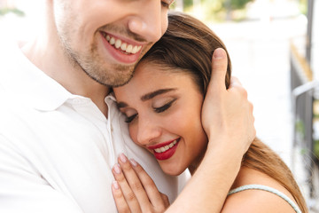 Loving couple walking outdoors while hugging.