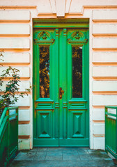 Fototapeta na wymiar green entrance door on orange facade