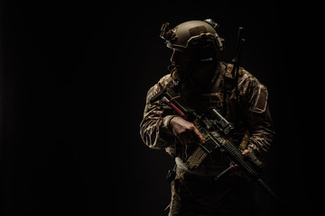 Special forces United States soldier or private military contractor holding rifle. Image on a black background.
