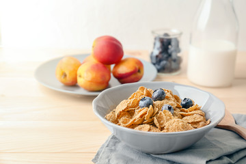 Bowl with healthy cornflakes and blueberry on wooden table