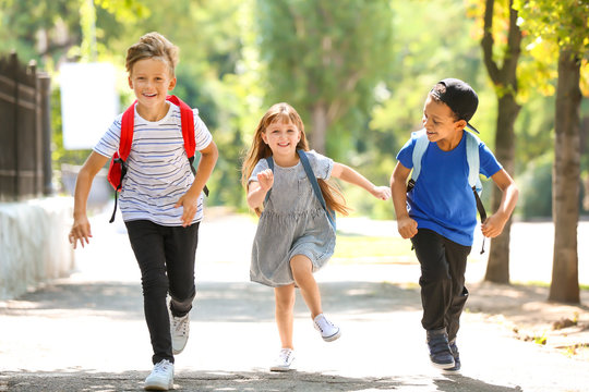 Cute Little Schoolchildren Running Outdoors