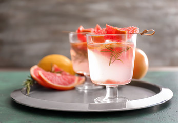 Fresh grapefruit cocktail with rosemary in glass on metal tray