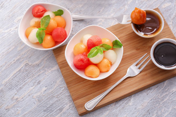 Plates with tasty melon dessert on wooden table