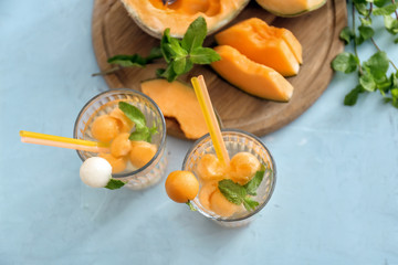 Glasses of delicious cocktails with melon balls on light table