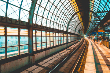 steel train station with big glass facade and blurred traveler