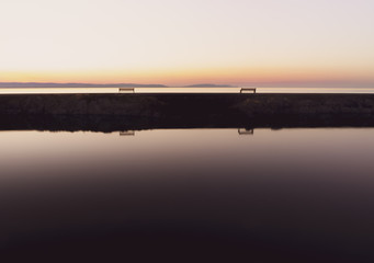 Abendstimmung am Wasser mit zwei Bänken - minimalistisch
