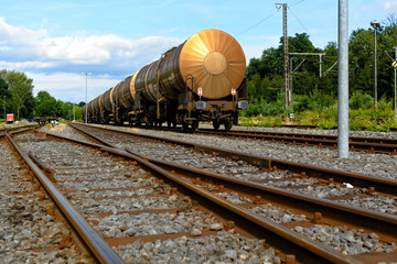 Ein Eisenbahnwagon steht auf Schienen in einem Bahnhofsgelände