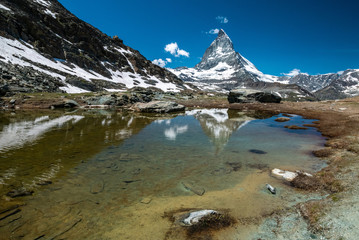 Obraz premium Scenic view of Matterhorn and its reflection on Riffelsee, an alpine lake of Riffelhorn in Zermatt, Switzerland.