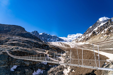 Obraz premium Scenic veiw of hanging bridge over the Glacier de Corbassiere on a mountain trail around Valais Swiss Alps.