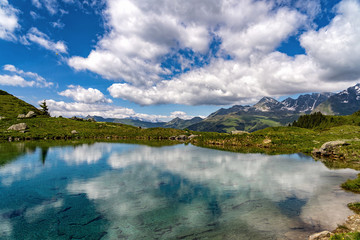 Scenic view of beautiful landscape in Swiss Alps. Fresh green meadows and snow-capped mountain tops...