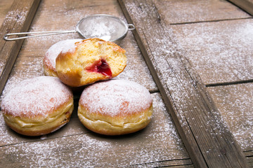 Traditional Polish donuts on wooden background.  Tasty doughnuts with jam.