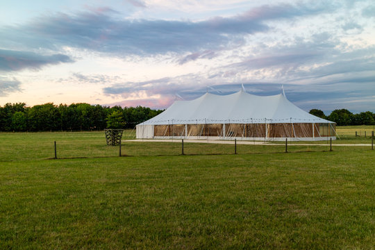 A marquee set up in a field in the evening
