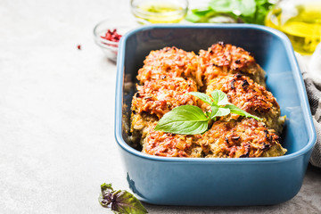 Oven baked chicken and vegetable rissoles in baking dish. Selective focus, space for text.