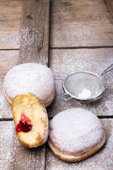 Traditional Polish donuts on wooden background.  Tasty doughnuts with jam.