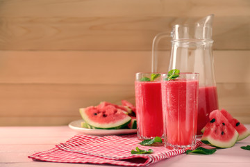 Glasses and jug with fresh watermelon smoothie on table