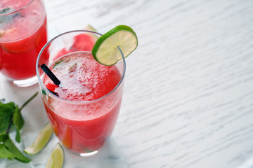 Glass with fresh watermelon smoothie on light table