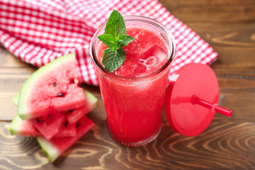 Glass with fresh watermelon smoothie on wooden table