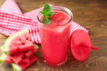 Glass with fresh watermelon smoothie on wooden table