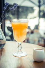 Orange fresh squeezed juice on the wooden table in the restaurant. Close up