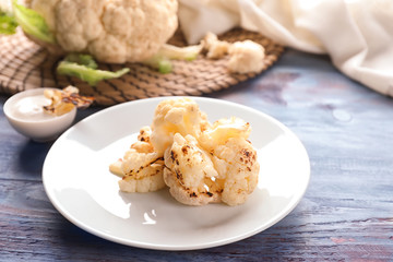 Plate with white cauliflower cabbage on wooden table