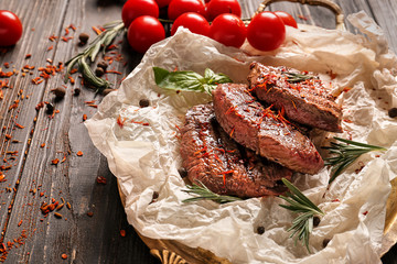 Metal tray with delicious grilled steaks on wooden table