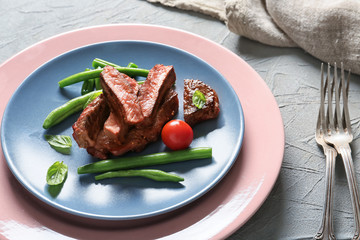 Cut grilled steak with green beans on plate