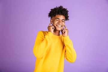 Portrait of satisfied african american boy having stylish afro hairdo smiling with closed eyes,...