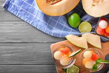 Composition with melon and balls on wooden table