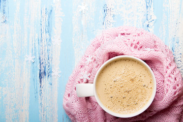 Smaczna Świąteczna biała kawa lub kakao otoczone pastelowym różowym kocem na niebieskim drewnianym tle. Miejsce na tekst.  - obrazy, fototapety, plakaty