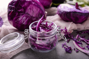 Obraz na płótnie Canvas Glass jar with cut cabbage on grey table