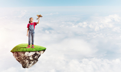 Concept of careless happy childhood with girl playing with airplane