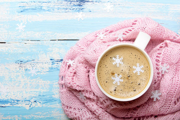 Smaczna Świąteczna biała kawa lub kakao otoczone pastelowym różowym kocem na niebieskim drewnianym tle. Miejsce na tekst. 