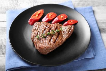 Tasty grilled steak with cut chili pepper on plate