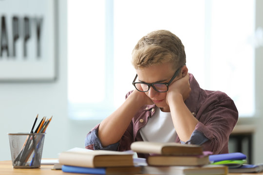 Teenager boy doing homework at home - Powered by Adobe