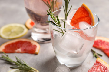 Fresh grapefruit cocktail with rosemary in glass on light table