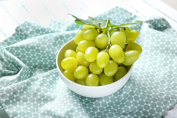 Bowl with fresh ripe grapes on napkin