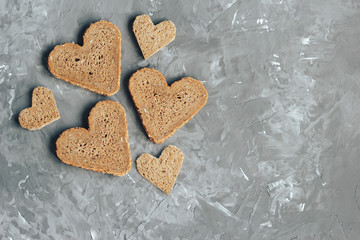 Rye bread in the shape of heart cut into slices on a gray background - 220099419