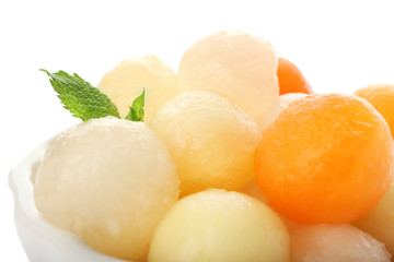 Bowl with delicious melon balls on white background, closeup