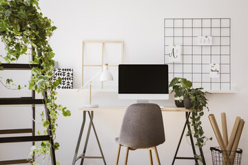 Real photo of white apartment interior with fresh plants, paper rolls in basket, organizer on wall...