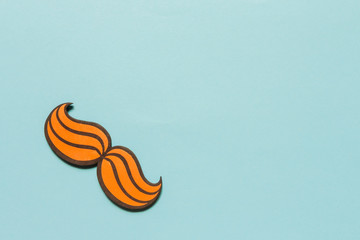 Flat composition with sunglasses mustache and blue ribbon on a blue background. Celebrating the Movember Day