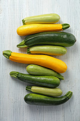Fresh zucchinis on white wooden table
