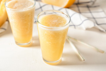 Glasses of delicious melon smoothie on white table