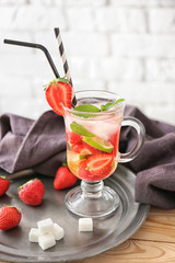 Glass cup of fresh strawberry mojito on metal tray