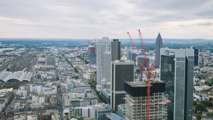 aerial view of cityscape with skyscrapers and buildings near crane in Frankfurt, Germany