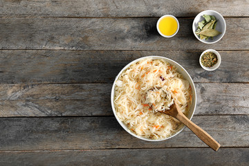 Bowl with homemade sauerkraut on wooden table