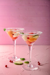 Glasses of delicious cocktails with melon balls on color table