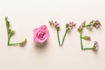 Word LOVE made of beautiful flowers on light background