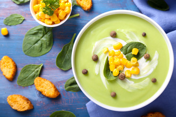 Bowl with delicious zucchini soup on color table