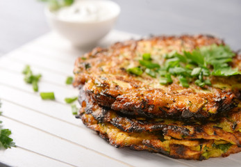 Zucchini pancakes on wooden board, closeup